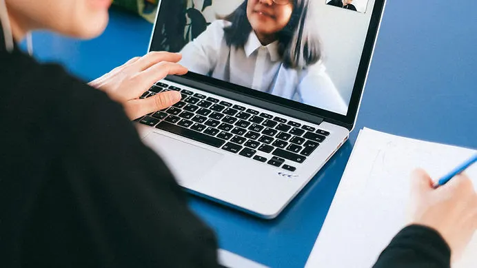 Background image of a laptop with hands typing, symbolizing productivity and engagement with the services offered on the page